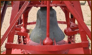 Bell on a red buoy standing on sand